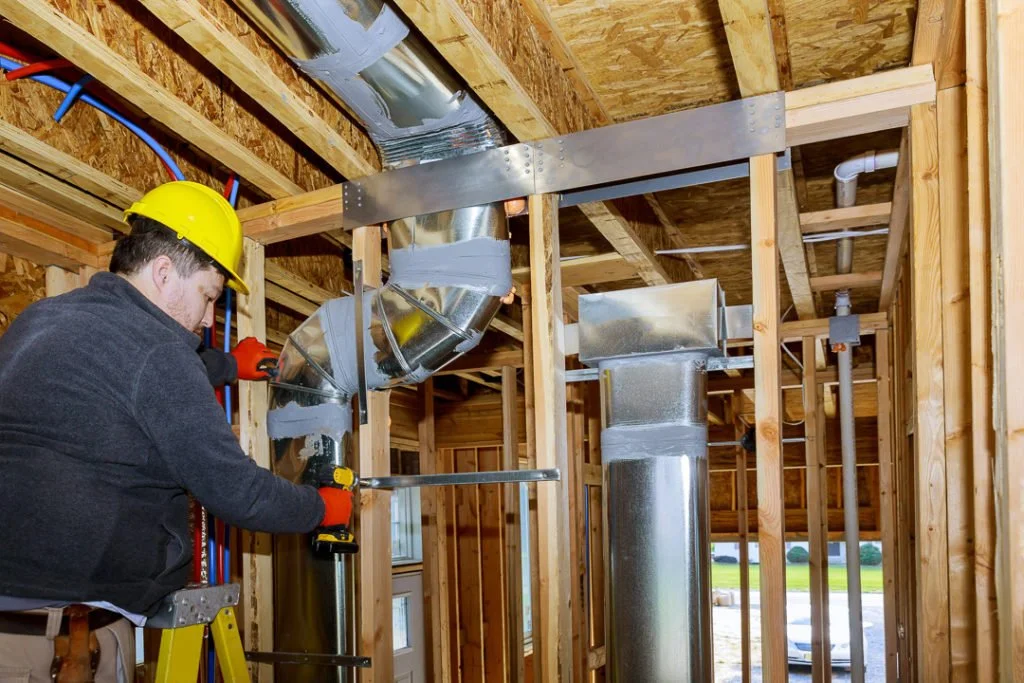 Installation system HVAC duct ventilation pipes in silver insulation of central conditioning a wall