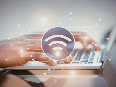 Smart contacts concept. Illustration of wifi icon with electronic connections, woman's hands using laptop on background.