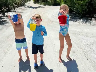 several children enjoying the day pass. holding sea shells in buckets